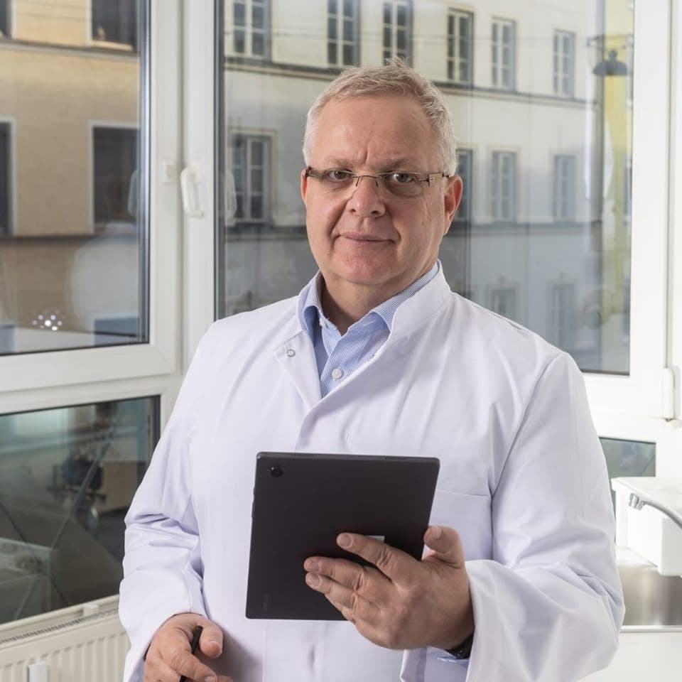 Gary Treskunov im Laborkittel mit Tablet, im Hintergrund die Fensterfront des Münchner Labors