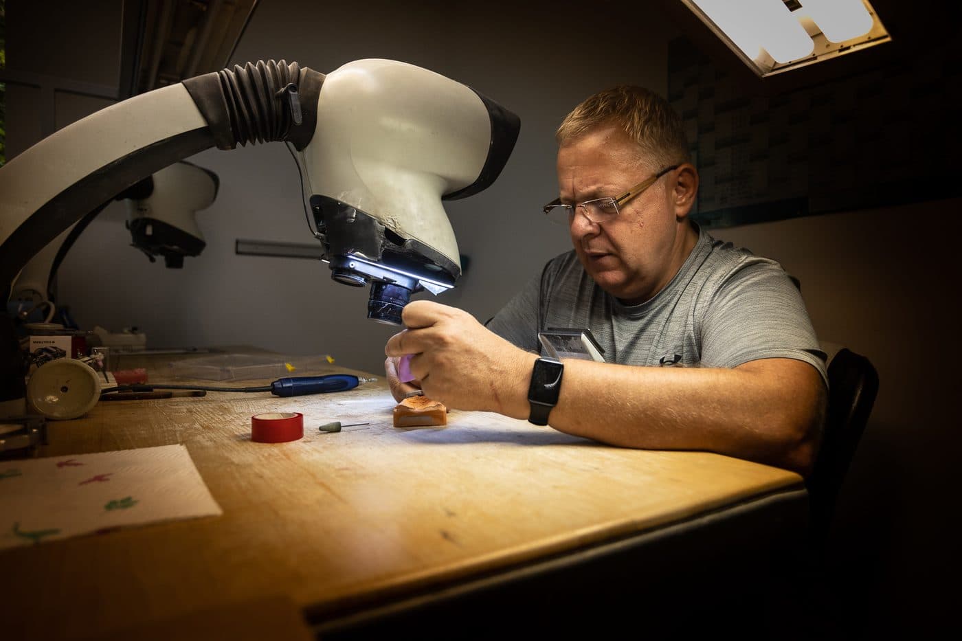 Gary Treskunov prüft eine zahntechnische Arbeit unter dem Mikroskop